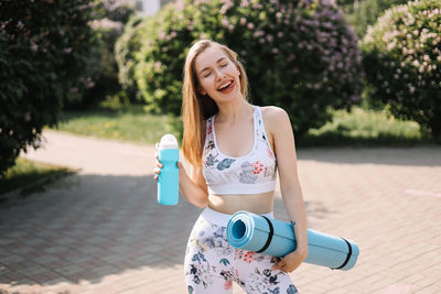 Portrait of a smiling young woman holding camera