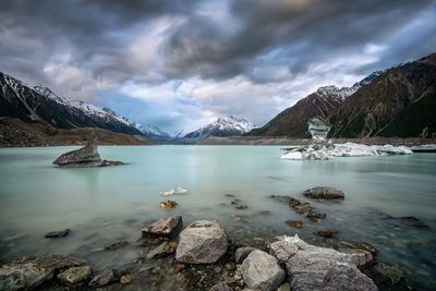 Scenic view of lake by snowcapped mountain against sky