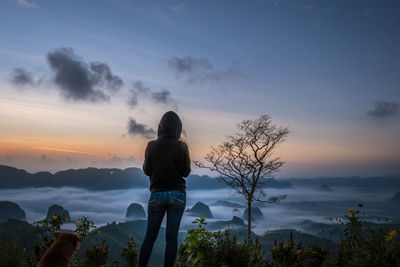 Rear view of silhouette man looking at sunset