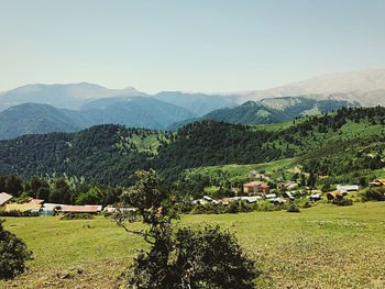 Scenic view of field by mountains against sky