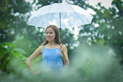 Happy girl standing on wet rainy day