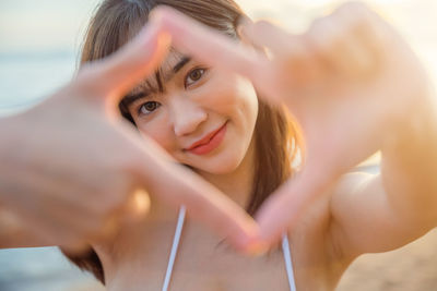 Low angle view of young woman sitting at beach