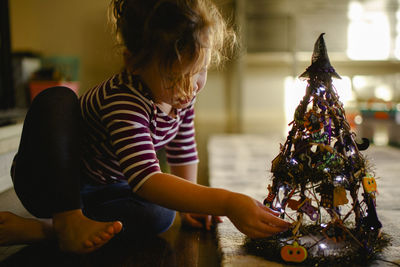 A barefoot child explores a toy in beautiful light