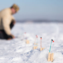  focus on fishing nets for ice fishing, blurred fisherman checks fishing rod, winter frosty day