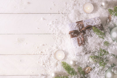 Close-up of christmas gift covered in snow on table
