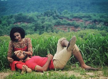 Portrait of father and daughter sitting on grass