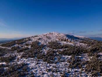 Scenic view of snowcapped mountains against clear blue sky