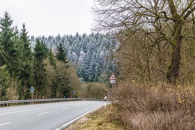 Road amidst trees against clear sky