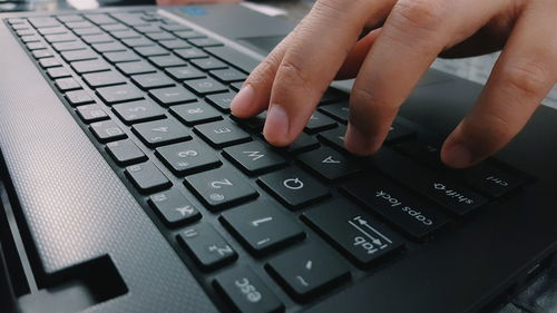 Cropped image of person using laptop