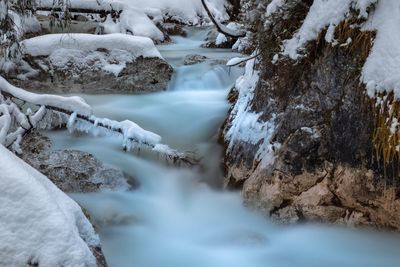 River flowing through rocks during winter