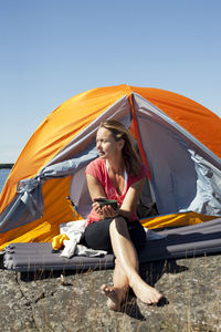 Woman sitting in front of tent