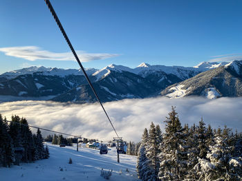 Scenic view from schönleiten cable car ski lift to snow covered mountains against blue sky