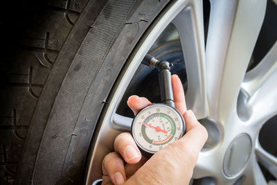 Cropped hand examining air pressure in tire 