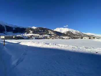 Scenic view of snowcapped mountains against clear blue sky