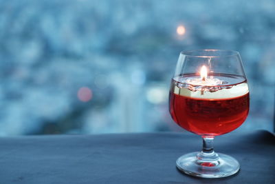 Close-up of tea light candle in wineglass on table