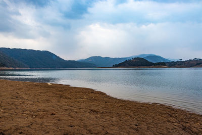 Lake calm water with mountain background at day from flat angle