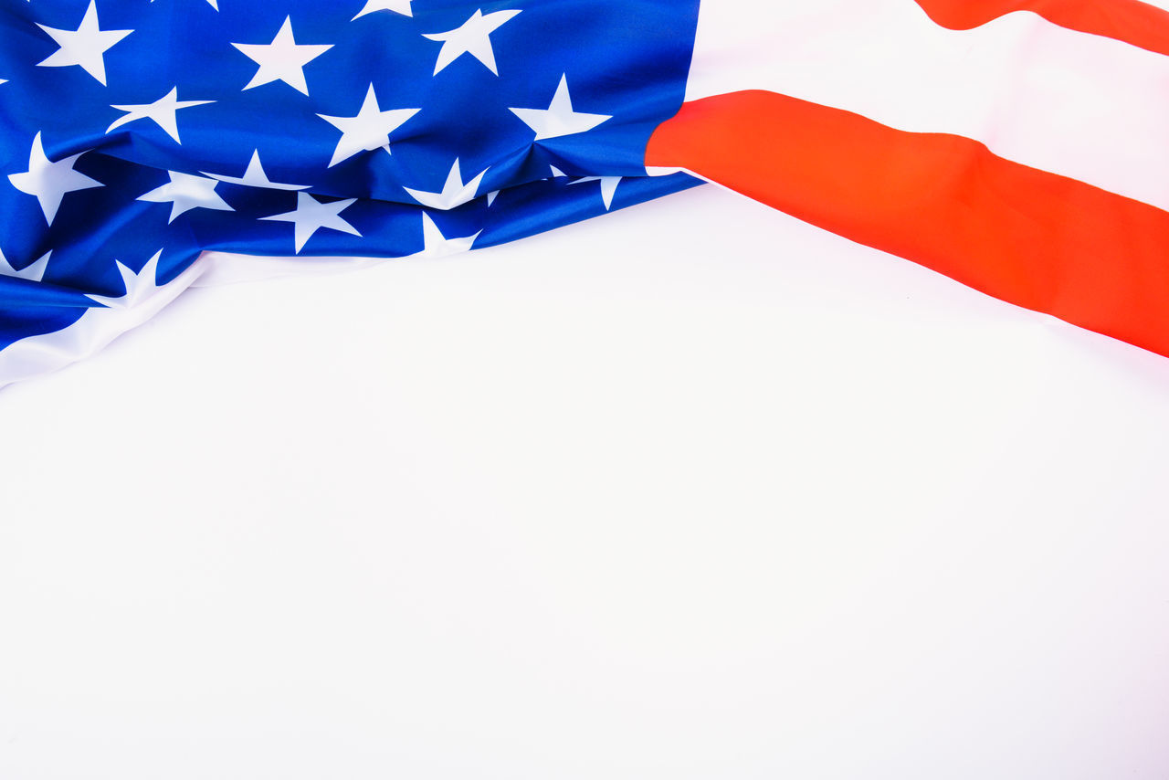 CLOSE-UP OF WHITE FLAGS AGAINST BLUE SKY