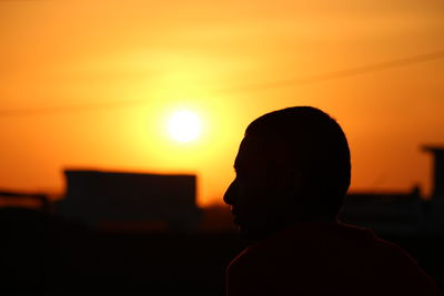 Silhouette boy against sky during sunset