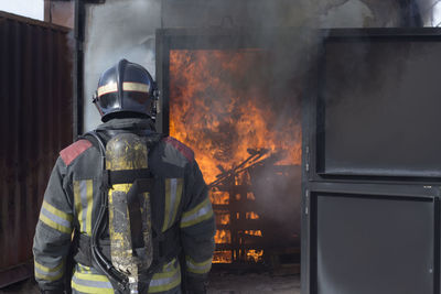 Rear view of firefighter working outdoors