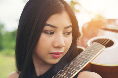 Close-up of young woman holding guitar