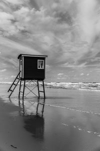 Lifeguard hut at beach against sky