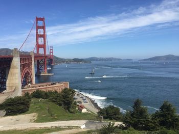 Suspension bridge over sea against sky