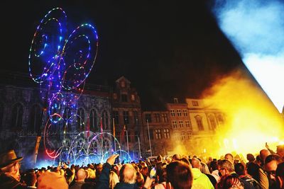 Crowd at music concert against sky at night