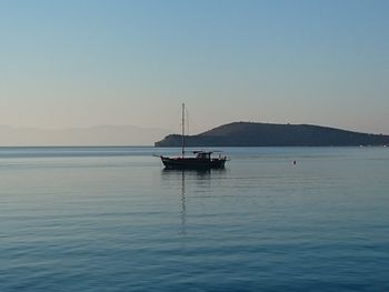 Boat sailing on sea against clear sky