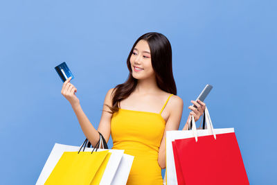 Smiling young woman using mobile phone