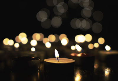 Close-up of tea light candles in darkroom