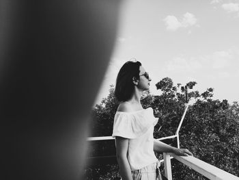 Side view of woman standing against sky