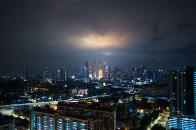 Illuminated cityscape against sky at night