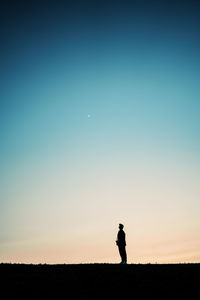 Silhouette woman standing against clear sky during sunset