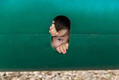 Close-up of portrait of child looking through hole