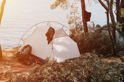 Tent vacationing relaxing traveler on the seashore. camping on a trip and hiking on the ocean or sea