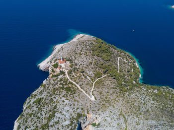 High angle view of island amidst sea against blue sky