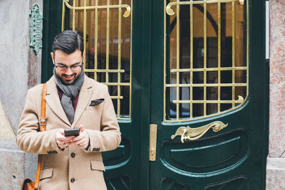 Full length of young man using mobile phone