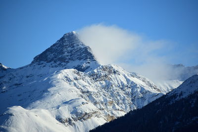 Low angle view of snowcapped mountains against sky