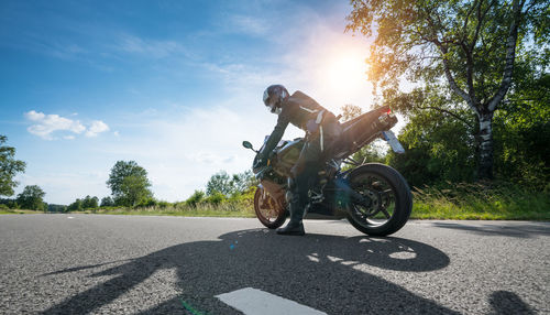 Man riding bicycle on road against sky