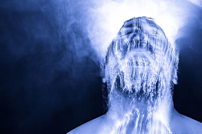 Digital composite image of man with light painting against black background