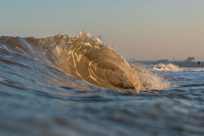 Water splashing in sea against sky