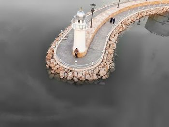 High angle view of lighthouse on pier by sea