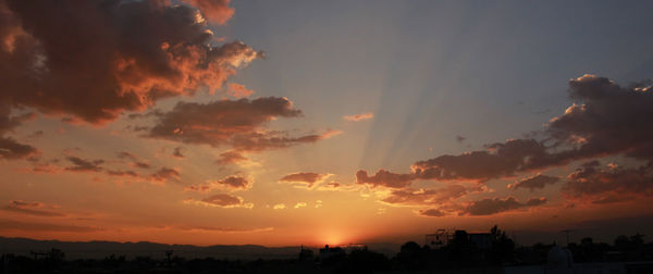 Silhouette cityscape against sky during sunset