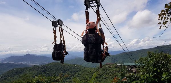 Low angle view of overhead cable car against sky