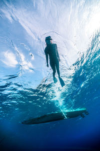Silhouette man in sea against sky during winter