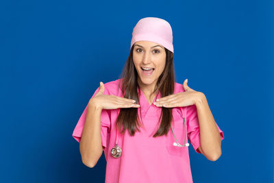 Portrait of a smiling young woman against blue background