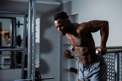 Shirtless athlete exercising in gym