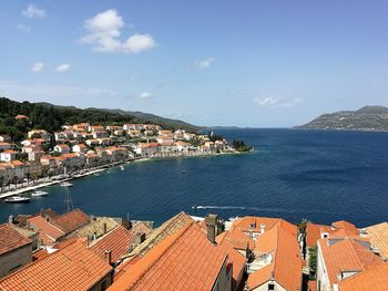 High angle view of townscape by sea against sky