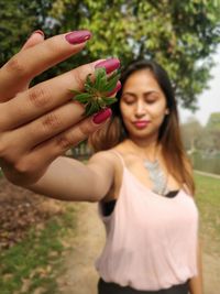 Beautiful young woman holding leaf