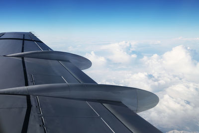 Cropped image of airplane against cloudy sky